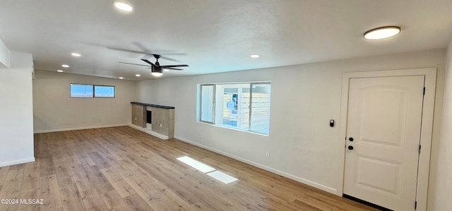 unfurnished living room with light hardwood / wood-style floors, a wealth of natural light, and ceiling fan