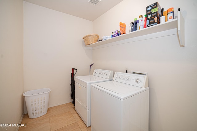 clothes washing area with light tile patterned flooring and independent washer and dryer