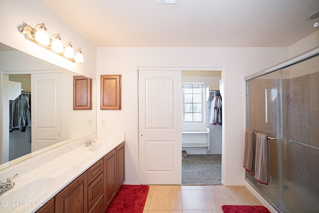 bathroom with tile patterned floors, vanity, and a shower with shower door