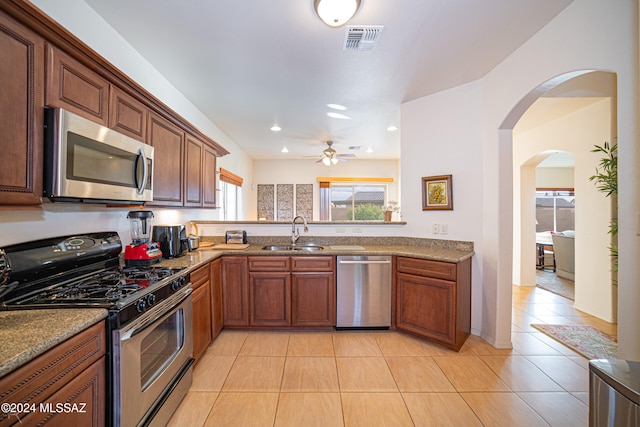 kitchen featuring stainless steel appliances, sink, light tile patterned floors, and ceiling fan