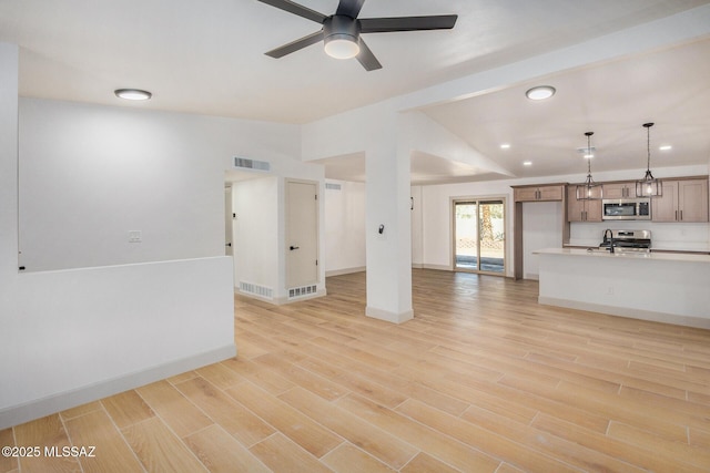 unfurnished living room featuring lofted ceiling, ceiling fan, and light wood-type flooring