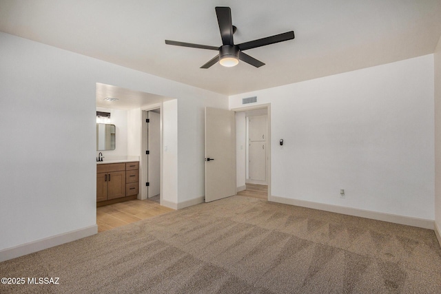 unfurnished bedroom featuring ceiling fan, connected bathroom, and light carpet