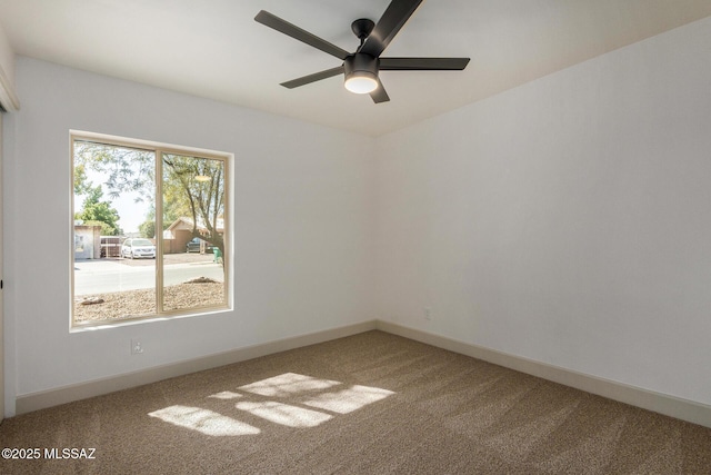 unfurnished room with ceiling fan and carpet