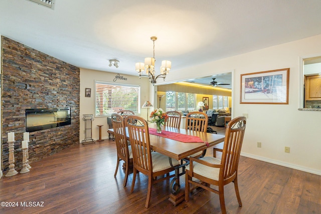 dining space featuring a fireplace, ceiling fan with notable chandelier, and dark hardwood / wood-style floors