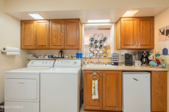 laundry area with washing machine and clothes dryer and sink