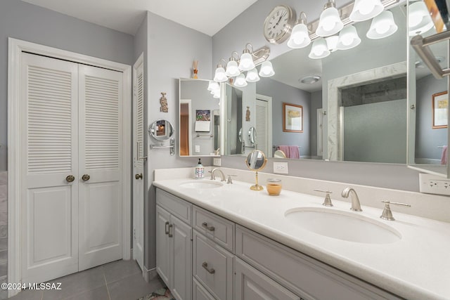 bathroom featuring tile patterned flooring, vanity, and a shower