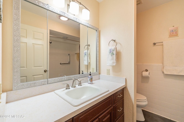 bathroom featuring vanity, toilet, and tile walls