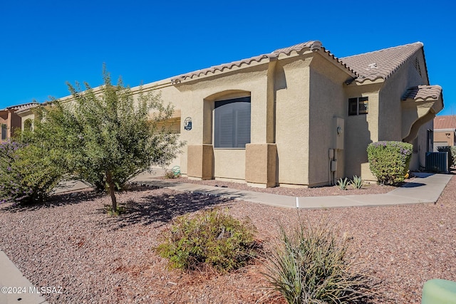 mediterranean / spanish home featuring stucco siding, a tile roof, and central AC unit