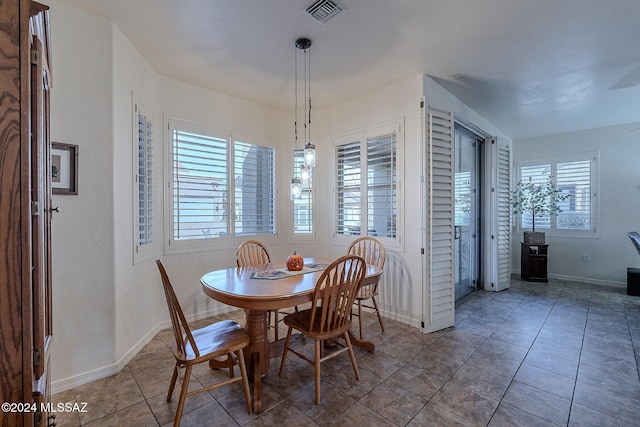 dining space with baseboards and tile patterned flooring