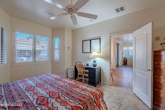 tiled bedroom featuring ceiling fan