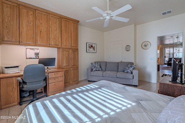 bedroom featuring ceiling fan, built in desk, and light tile patterned flooring