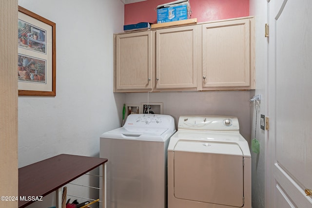 laundry area with separate washer and dryer and cabinets