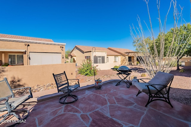 view of patio with fence and a grill