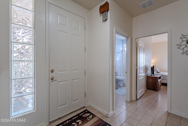 foyer entrance with a wealth of natural light and light tile patterned flooring