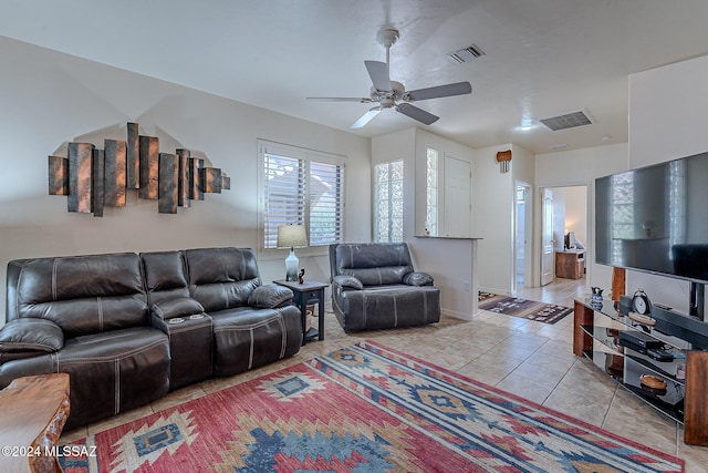 living room featuring light tile patterned floors, ceiling fan, and baseboards