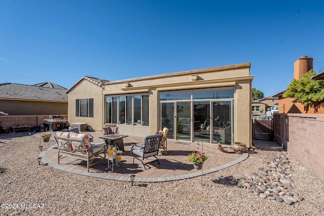 rear view of house featuring a patio and an outdoor living space