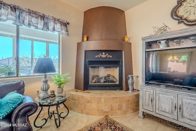 living room featuring a tile fireplace and light tile patterned floors