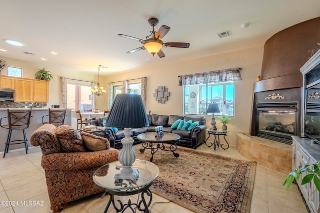 living room featuring ceiling fan with notable chandelier and light tile patterned flooring