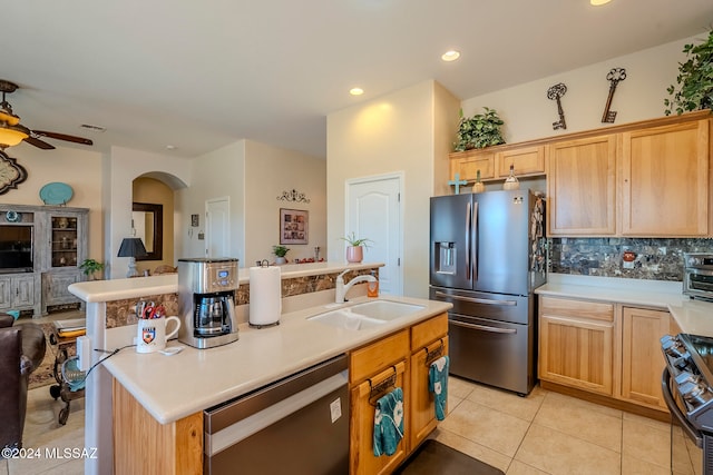 kitchen with appliances with stainless steel finishes, decorative backsplash, sink, an island with sink, and ceiling fan