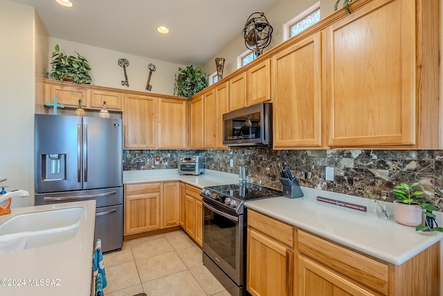 kitchen featuring stainless steel appliances, light tile patterned flooring, sink, and backsplash