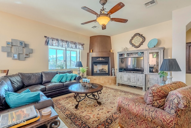 living room featuring tile patterned floors, a tile fireplace, and ceiling fan