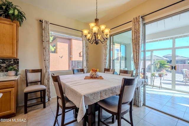 dining space with a chandelier, light tile patterned floors, and plenty of natural light