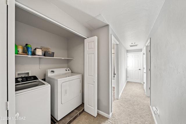 laundry area featuring washing machine and clothes dryer and light carpet