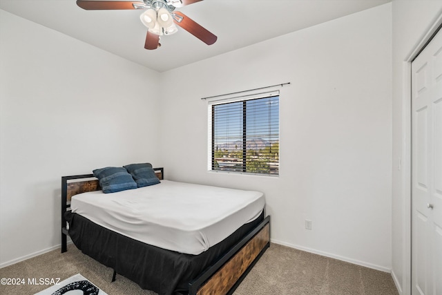 bedroom featuring ceiling fan, a closet, and light colored carpet