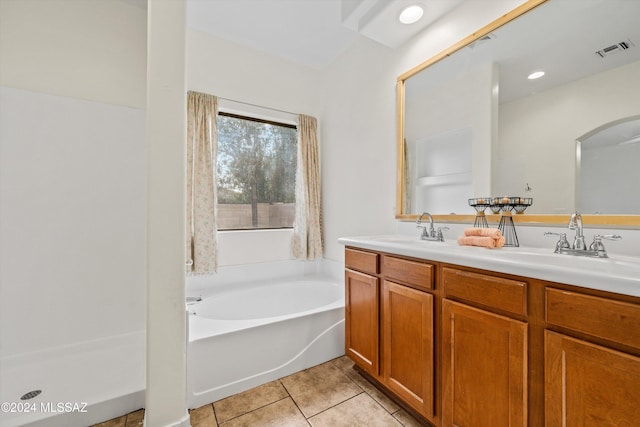 bathroom with tile patterned floors, a bathing tub, and vanity