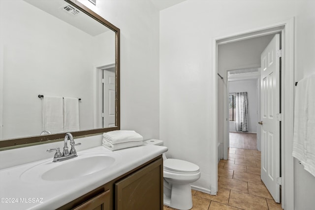 bathroom with vanity, toilet, and tile patterned floors