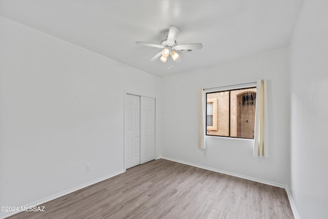 unfurnished bedroom featuring light hardwood / wood-style floors, a closet, and ceiling fan