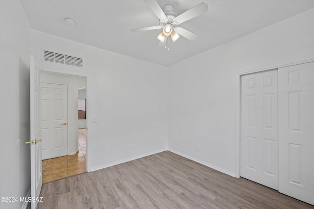 unfurnished bedroom featuring light wood-type flooring, a closet, and ceiling fan