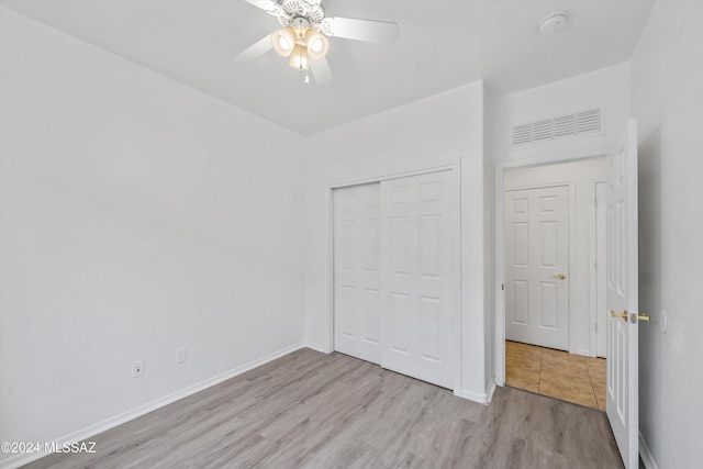 unfurnished bedroom featuring ceiling fan, a closet, and light hardwood / wood-style floors