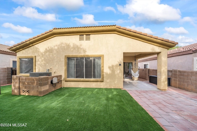 rear view of house with a yard and a patio area