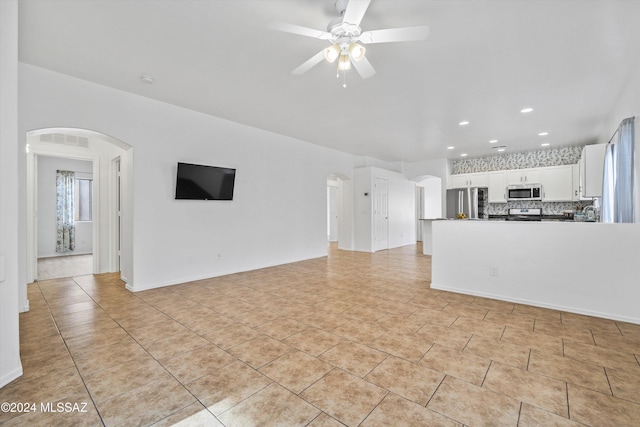 unfurnished living room with ceiling fan and light tile patterned floors