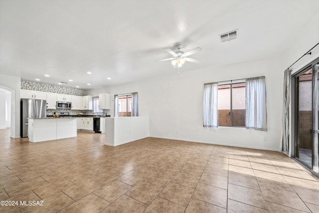 unfurnished living room with ceiling fan and light tile patterned floors