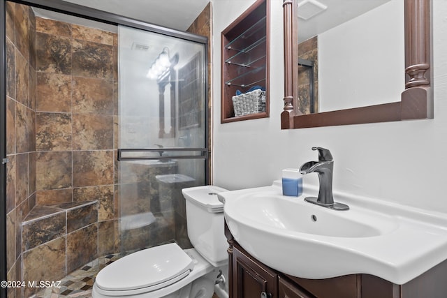 bathroom with vanity, toilet, and a shower with door