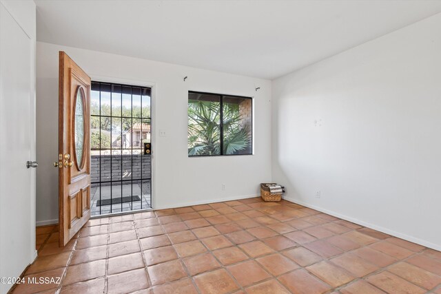 empty room with a wealth of natural light and light tile patterned flooring
