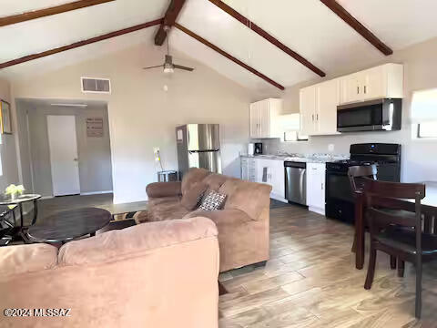 living room featuring ceiling fan, beam ceiling, light wood-type flooring, and high vaulted ceiling