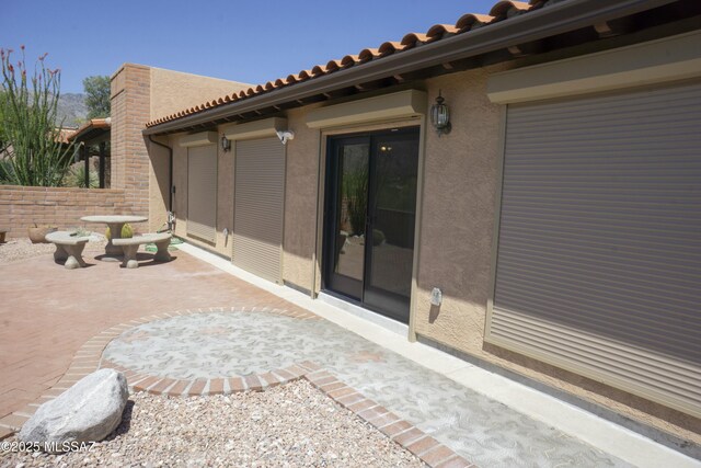 view of home's exterior featuring a tile roof, a patio, and stucco siding