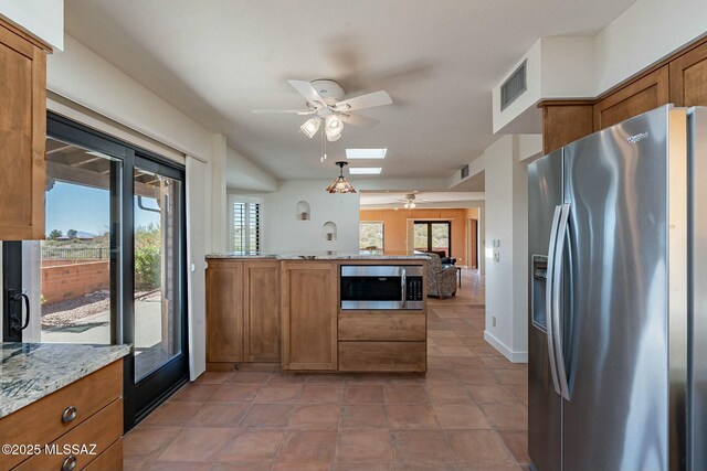 dining area featuring a skylight, light tile patterned flooring, and baseboards