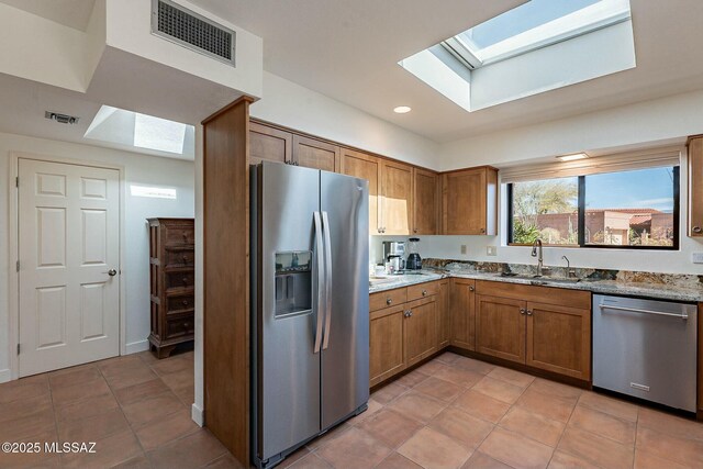 dining area with a skylight, light tile patterned floors, and baseboards