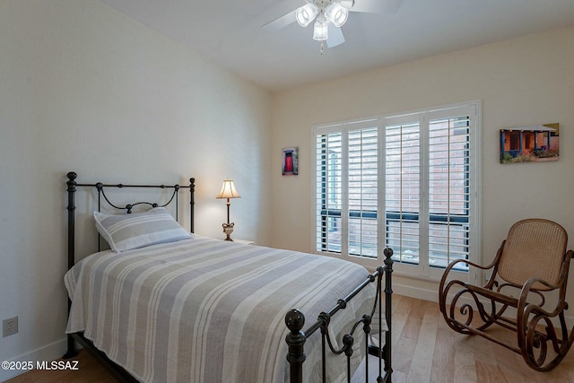 bedroom featuring ceiling fan, baseboards, and wood finished floors