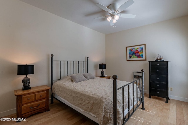 bedroom with light wood-type flooring, a ceiling fan, and baseboards