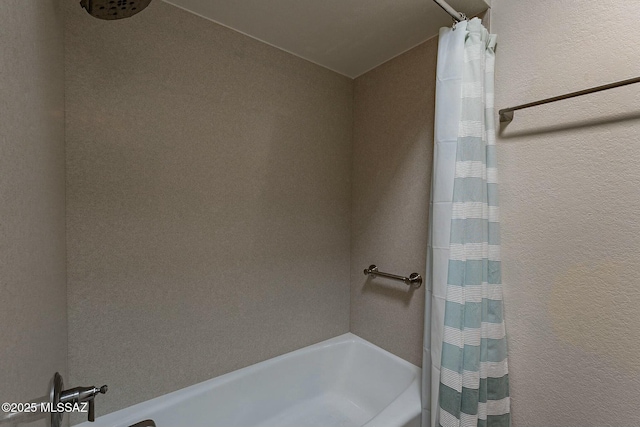 full bathroom with shower / bathtub combination with curtain and a textured wall