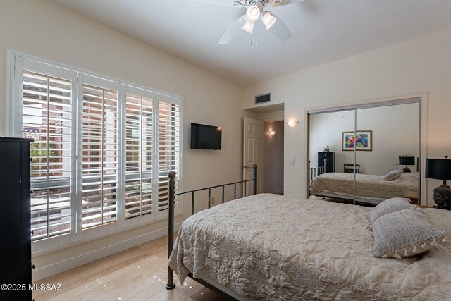 bedroom featuring a closet, light wood-type flooring, visible vents, and a ceiling fan