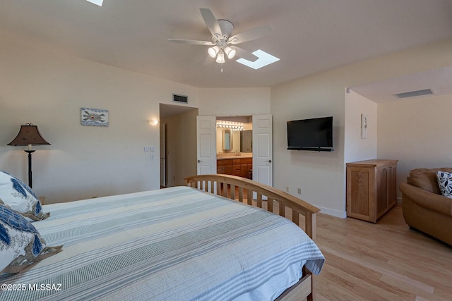 bedroom featuring light wood-type flooring, a skylight, visible vents, and a ceiling fan