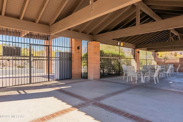 view of patio with outdoor dining space, fence, and a gazebo