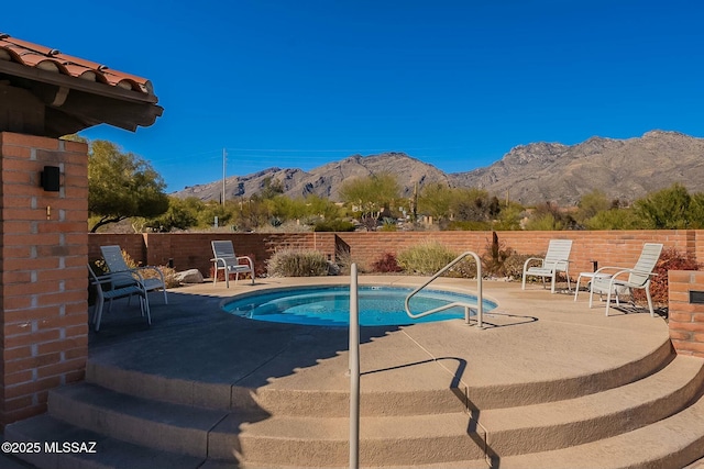 view of pool featuring a swimming pool, a patio area, a fenced backyard, and a mountain view