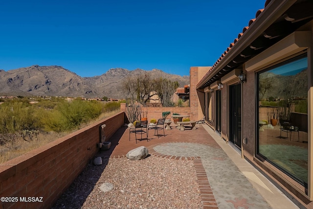 view of patio / terrace with fence and a mountain view